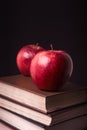 Red apple on book stack on black background Royalty Free Stock Photo