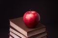 Red apple on book stack on black background Royalty Free Stock Photo