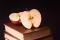 Red apple on book stack on black background Royalty Free Stock Photo