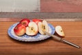 Red apple on the wooden table, cut with the knife