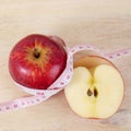 Red apple with centimeter on wood table for diet concept Royalty Free Stock Photo