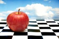 Red apple on chessboard