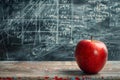 Red apple on desk with math formulas on blackboard in background Royalty Free Stock Photo