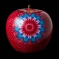 A red apple features a digitally applied, intricate mandala design on its surface. The Royalty Free Stock Photo