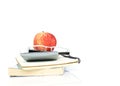 Red apple fruits put on glasses and calculator and book stack