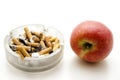 Red apple with full ashtray Royalty Free Stock Photo