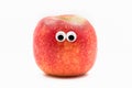 Red apple with googly eyesy on white background - fruit face