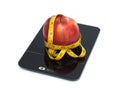 Red apple on kitchen scales with measuring tape isolated closeup Royalty Free Stock Photo