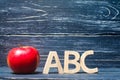 Red apple and letters ABC on a dark background of a school board Royalty Free Stock Photo