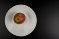 Red apple lies on a plate Royalty Free Stock Photo