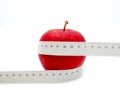 Red apple and measure tape centimeter that represent reduce weight or diet food and exercise for body good shape design concept Royalty Free Stock Photo