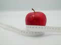 Red apple and measure tape centimeter that represent reduce weight or diet food and exercise for body good shape design concept