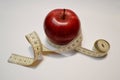 Red apple with measure tape on white background Royalty Free Stock Photo