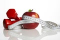 Red apple with measuring tape and weight dumbbells Royalty Free Stock Photo