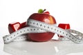 Red apple with measuring tape and weight dumbbells Royalty Free Stock Photo