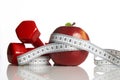 Red apple with measuring tape and weight dumbbells Royalty Free Stock Photo