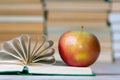 A red apple and an open book, the pages of the book are gathered in a fan for beauty Royalty Free Stock Photo