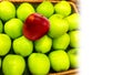 Red apple on pile of green group in wicker basket for sale at market Royalty Free Stock Photo