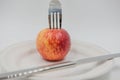 Red apple on plate and fork , knife on white background. Royalty Free Stock Photo