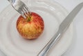 Red apple on plate and fork , knife on white background. Royalty Free Stock Photo