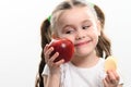 Red apple and potato chips, healthy and unhealthy food for children, little girl makes a choice between healthy and Royalty Free Stock Photo