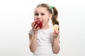 Red apple and potato chips, healthy and unhealthy food for children, little girl makes a choice between healthy and Royalty Free Stock Photo