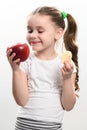 Red apple and potato chips, healthy and unhealthy food for children, little girl makes a choice between healthy and Royalty Free Stock Photo