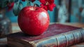 A Red Apple Resting on an Old Leather-Bound Book Royalty Free Stock Photo