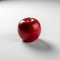 Red apple sits on a white surface casting a soft shadow to the Royalty Free Stock Photo