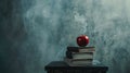 A red apple sitting on top of a stack of books on top of a black table Royalty Free Stock Photo