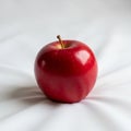 Red apple with smooth skin and a small stem sits on a white, Royalty Free Stock Photo