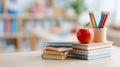 Red apple on stack of notebooks with pencils in classroom. Concept of back to school, teacherâs day, and education learning Royalty Free Stock Photo