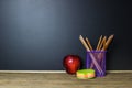 Red apple and stationery on wood table with Blackboard Royalty Free Stock Photo