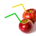 Red apple with a straw for a cocktail on a white background. Royalty Free Stock Photo