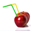 Red apple with a straw for a cocktail on a white background. Royalty Free Stock Photo