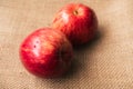 Red apple, 2 sweet red apples placed on a brown sackcloth surface, ready to eat. Ripe red apples have a wet skin that looks.