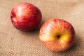 Red apple, 2 sweet red apples placed on a brown sackcloth surface, ready to eat.