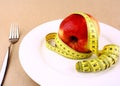 Red apple and tape measure on white plate with fork Royalty Free Stock Photo