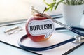 Red apple with text Botulism and measuring tape on background
