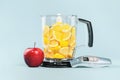 Red apple thermometer and blender full of bright cut lemons