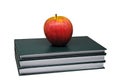 Red apple on top of three green hard-cover books isolated on white background. Royalty Free Stock Photo