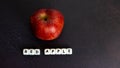 Red apple with white writing on dark background Royalty Free Stock Photo