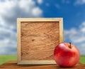 Red apple with wooden frame Royalty Free Stock Photo