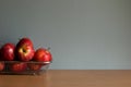 Red apples in an aluminum sieve container on wooden table and grey background. Royalty Free Stock Photo