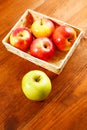 Red apples in basket on wooden table Royalty Free Stock Photo