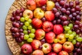 Red apples and grapes on a wicker dish. Harvest