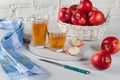 Red apples, juice in glasses, blue napkin and a knife on white table Royalty Free Stock Photo