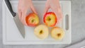 Red apples and a kitchen knife close-up on a white cutting board, flat lay, woman hands. Apple pie recipe Royalty Free Stock Photo