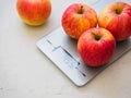 Red apples on kitchen scales on white background. Product weighing Royalty Free Stock Photo