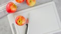 Red apples and a knife close-up on a white cutting board, flat lay Royalty Free Stock Photo